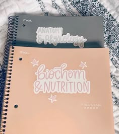 two notebooks sitting next to each other on top of a white bed sheet with the words bottom down and bottom down