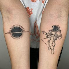 two people with tattoos on their legs, one has an astronaut and the other is an alien