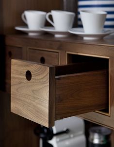 the drawers are open to show cups and saucers