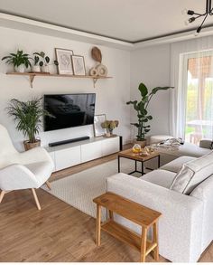 a living room filled with furniture and a flat screen tv mounted on a wall next to a window