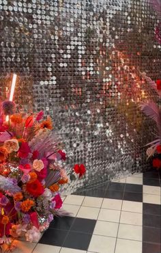 a large bouquet of flowers sitting on top of a tiled floor next to a wall