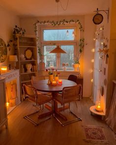 a dining room table with candles on it in front of a fire place and window