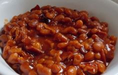 a white bowl filled with baked beans on top of a table