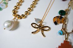 The cutest dainty bow necklace is here! The Coquette Bow necklace is made with a very delicate gold plated chain that has a bow and a shell heart charm. Necklace measures 17.5" long. Great to wear on its own or layer with other dainty necklaces Gold Butterfly Knot Necklace For Gift, Gold Necklaces With Butterfly Knot For Gift, Gold Necklace With Butterfly Knot For Gift, Gold Bow Necklaces For Gifts, Feminine Bow Jewelry For Gift, Gold Necklaces With Bow For Gifts, Gold Necklaces With Bow As Gifts, Gold Necklace With Bow For Gifts, Gold Necklace With Bow As Gift