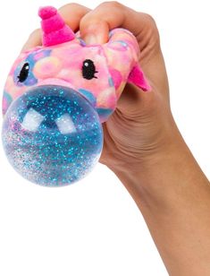 a hand holding a pink and blue toy