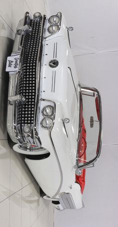 the back end of a white car with chrome grills and grilles on it