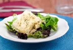 a white plate topped with salad on top of a blue place mat