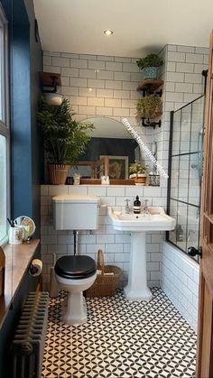 a bathroom with black and white tiles on the floor, toilet, sink and mirror