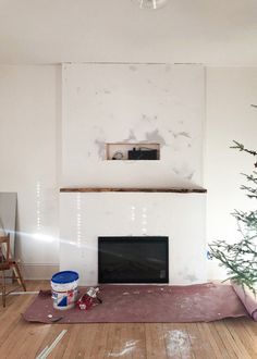 a living room with a christmas tree in the corner and a painting on the wall