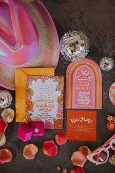 an orange and pink wedding suite with matching accessories, such as a hat, sunglasses, paperweights, and mirror balls