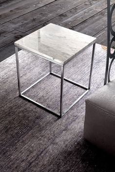 a glass table sitting on top of a gray rug