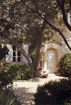 an entrance to a house surrounded by trees and bushes