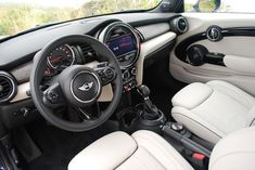 the interior of a car with all white leather seats and dashboards, including steering wheel