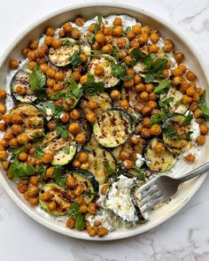 a white bowl filled with vegetables and chickpeas