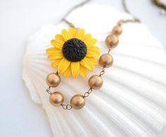 Golden Yellow Sunflower and Antique Gold Beads Asymmetrical Necklace. FREE EARRINGS Gold Flower-shaped Jewelry With Gold Beads, Gold Flower Jewelry With Gold Beads, Gold Floral Jewelry With Gold Beads, Gold Flower Beaded Chain Jewelry, Gold Flower Shaped Beaded Chain Jewelry, Gold Beaded Chain Flower Jewelry, Gold Flower-shaped Beaded Chain Jewelry, Gold Necklace With Flower Charm And Round Beads, Clay Sunflower