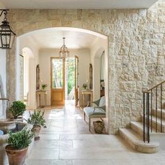 an entry way with stone walls and potted plants