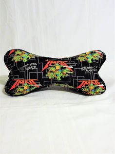 a black and orange dog bone with an image of plants on it