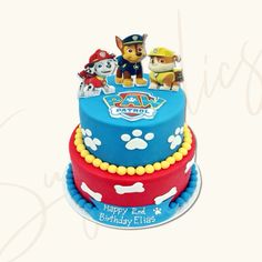 a birthday cake decorated with paw patrol characters and dog figurines on top of it