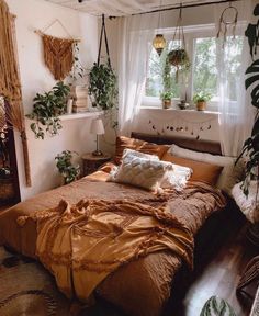 an unmade bed sitting in a bedroom next to a window with potted plants