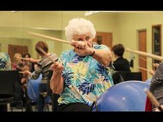 an older woman is practicing her moves in front of the audience at a dance class