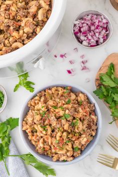 two bowls filled with food and garnished with cilantro, red onion, celery