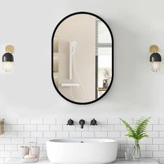 a bathroom with a round mirror above the sink and two lights on the wall next to it