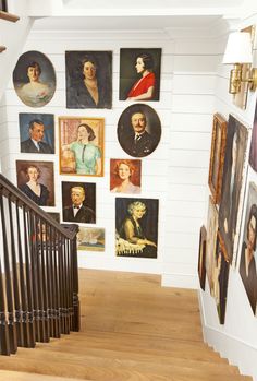 a staircase with pictures on the wall and wooden handrails in front of it