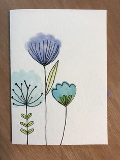 watercolor painting of blue flowers on white paper