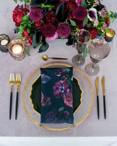 a place setting with flowers and candles on the table for an elegant dinner or party