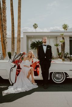 a bride and groom sitting in the back of a classic car with palm trees behind them