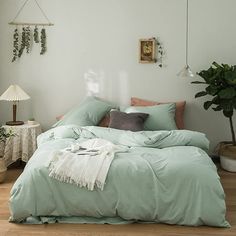 a bed sitting in a bedroom next to a window with plants on the wall behind it