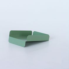 two green paper trays sitting side by side on a white surface with one folded up and the other closed