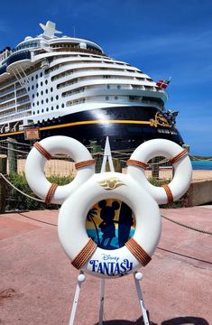 the disney cruise ship is in the background with life preservers on it's sides