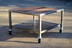 a metal table with a wooden top on wheels