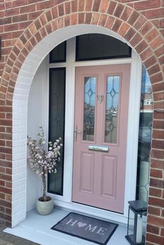 a pink front door with a welcome mat