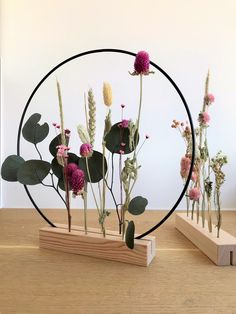 flowers are arranged in the shape of a circle on top of a wooden table next to a piece of wood