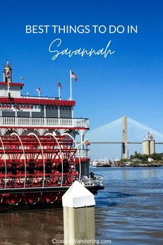 a large red boat floating on top of a river next to a tall white building