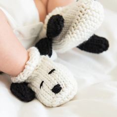 a close up of a baby's feet wearing crocheted slippers with a dog on it