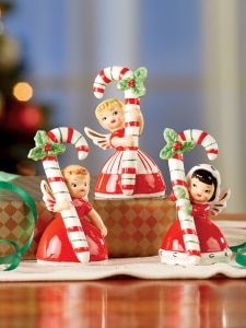 christmas figurines sitting on top of a table next to candy canes and decorations