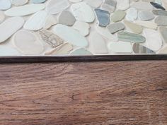 a wooden table topped with lots of different colored rocks