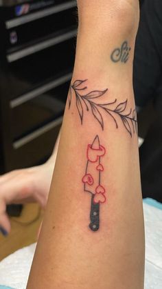 a person with a tattoo on their arm holding a knife and some mushrooms in it