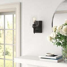 a vase filled with white flowers sitting on top of a table next to a mirror