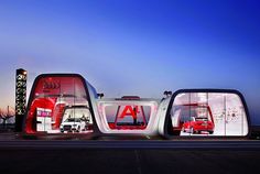 three futuristic cars are parked in front of each other on the road at night time