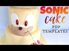 a person holding a knife in front of a cake with the words sonic cake on it