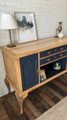 a blue and gold sideboard in a living room with a white brick wall behind it