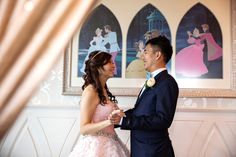 a man and woman standing next to each other in front of pictures on the wall