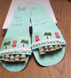 a pair of flip flops made out of paper with money on the bottom and palm trees