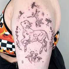 a woman with a tattoo on her arm has an image of a dog and mushrooms