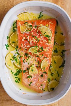 two salmon fillets in a bowl with lemons and parsley