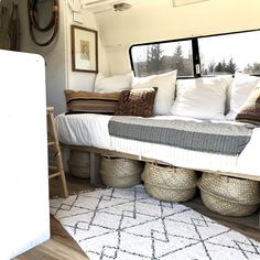 the interior of a camper with lots of pillows